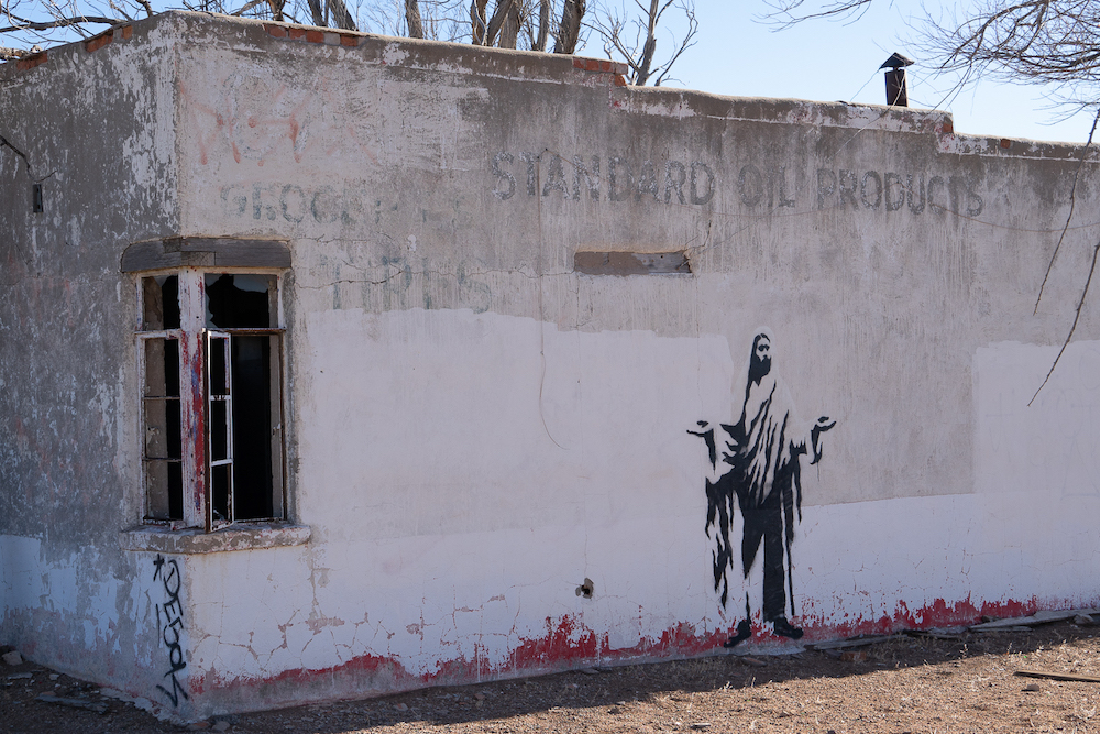 Jesus, oil products, groceries, tires, New Mexico, graffiti, abandoned building